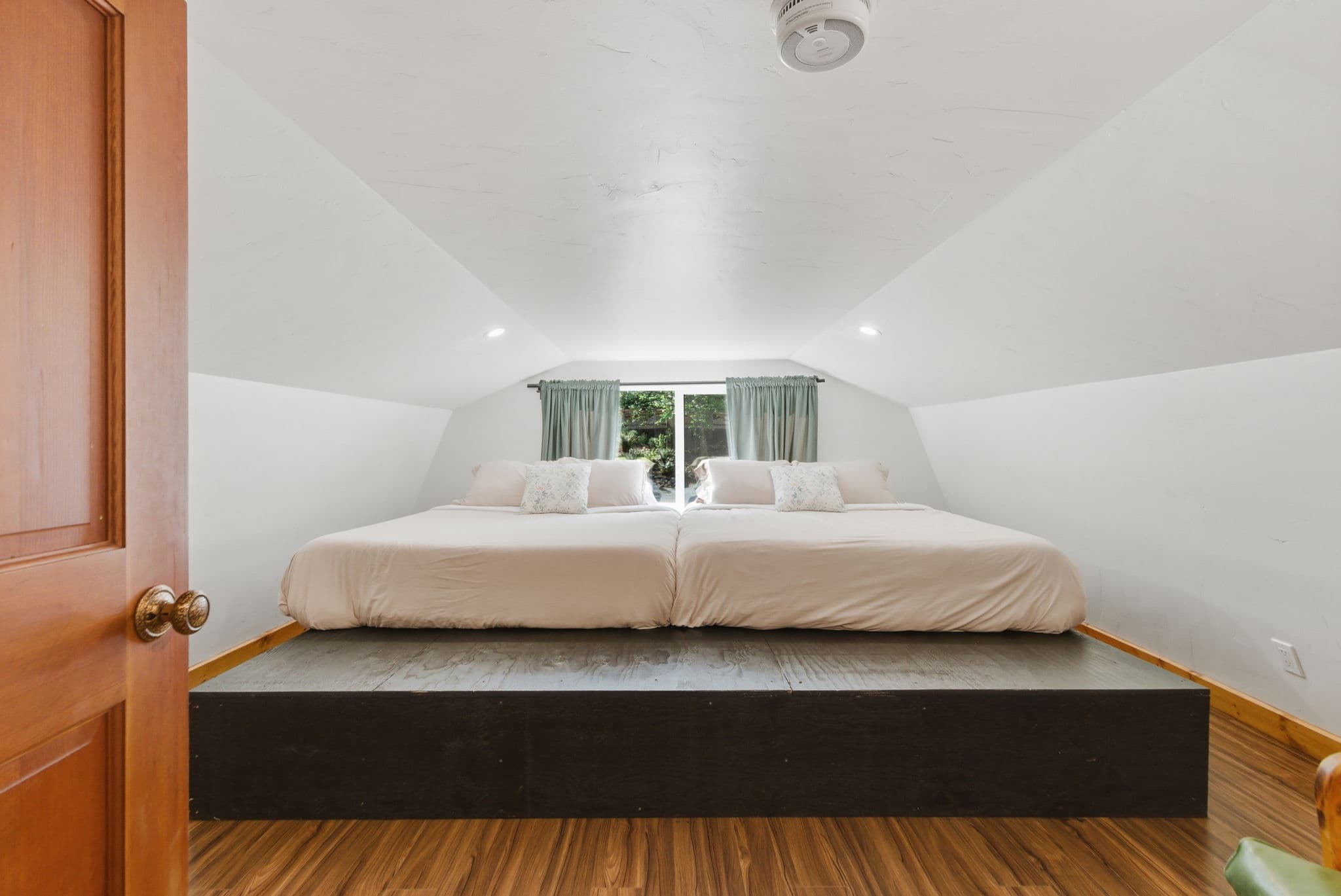 Loft sleeping platform with twin beds tucked under the eaves